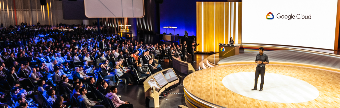 A speaker presents in front of a live audience at a Google Cloud event.